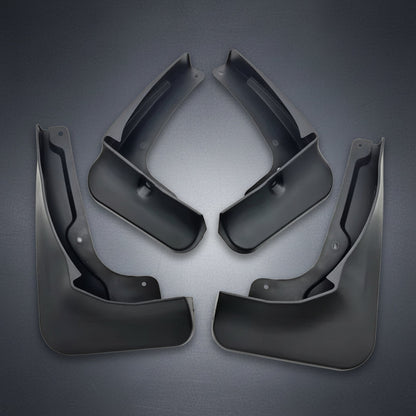 Four black plastic vehicle mud flaps arranged symmetrically on a plain white background.